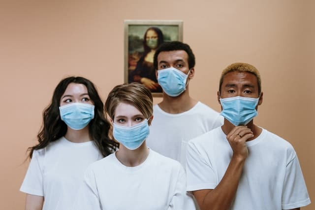Group of friends wearing the same white shirt and face mask.