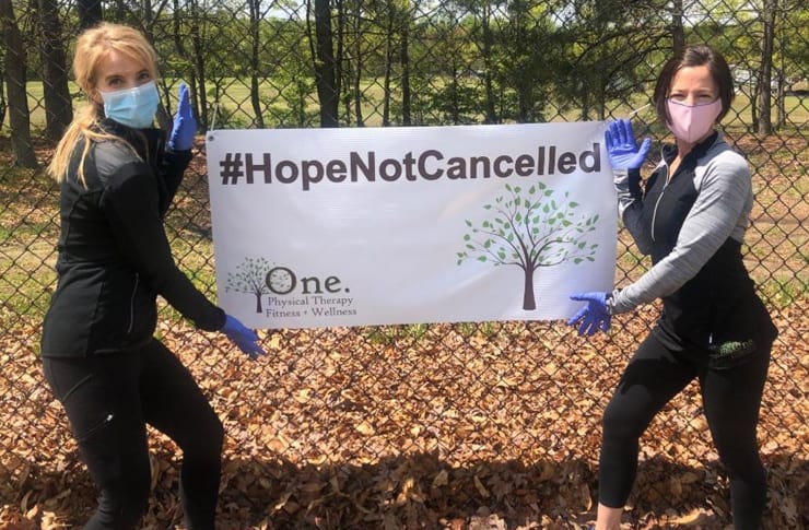 Christina and Jennifer holding a small tarpaulin saying hope not cancelled.