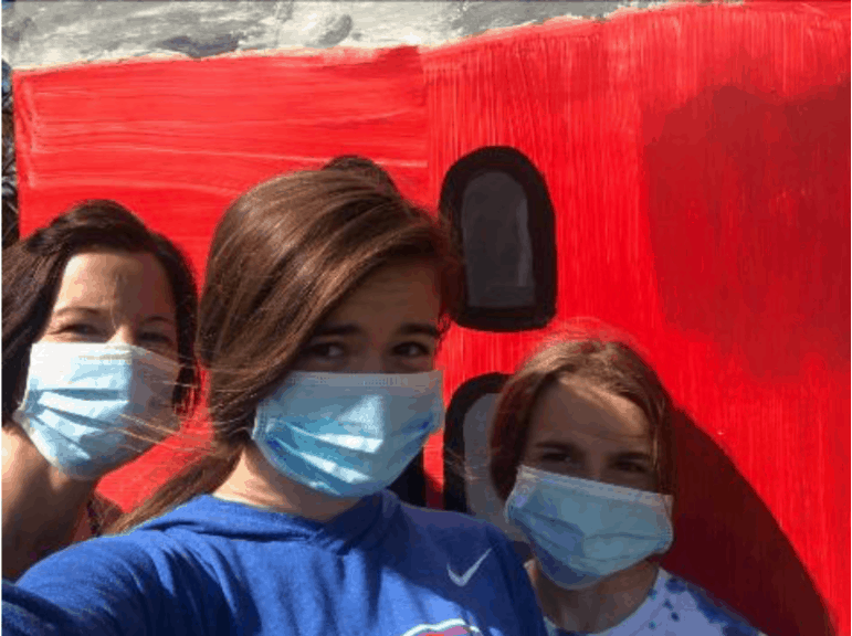 Three women taking a selfie while wearing face mask.