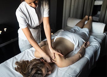 Woman receiving a massage from a masseuse.