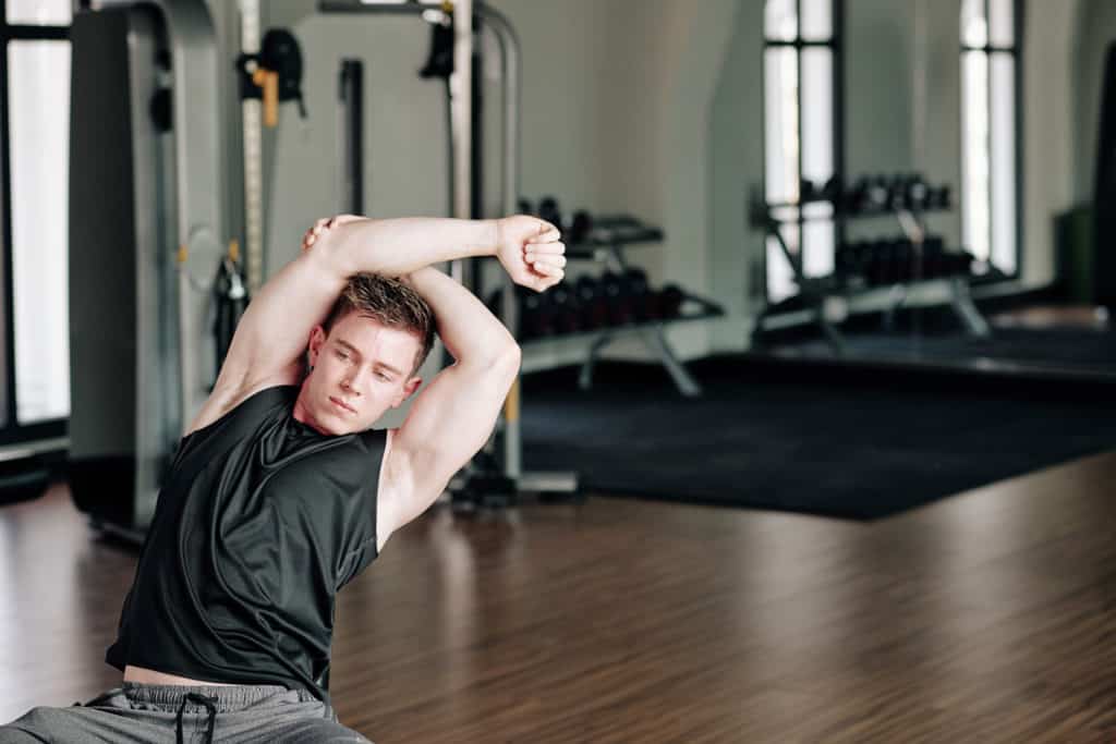Man doing stretches in a gym.