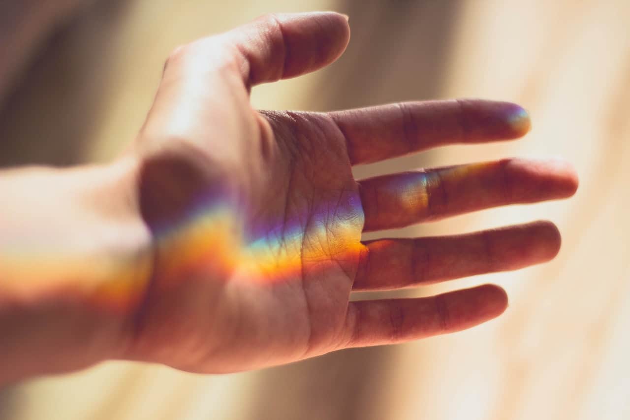 Reflection of a rainbow reflecting on a hand.