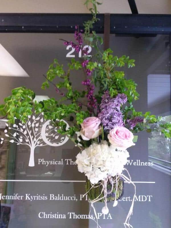 One Physical Therapy Fitness & Wellness logo printed on the glass with a beautiful flowers.